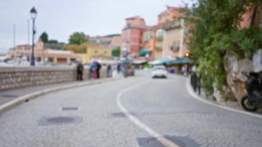 Renkli binalar ve insanları gösteren villefranche-sur-mer 'deki kaldırım taşı caddesinin bulanık görüntüsü