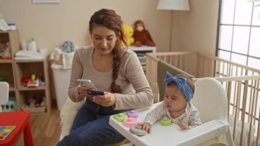 Annem akıllı telefon kullanıyor. Yanında kredi kartıyla ev odasındaki rahat koltukta oturan küçük çocuğun yanında aile sevgisini ve teknolojisini simgeliyor..