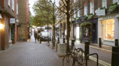 Bulanık kış sokağı manzarası yedi kadranda, Londra, dağılmış yayalar ve Bokeh ışıkları ile geleneksel bir Birleşik Krallık kaldırım taşı sokak atmosferini yakalıyor..