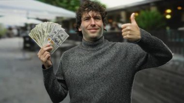 Bir şehir caddesinde gülümseyen ve el sallayan İspanyol asıllı bir adam, hareketli bir şehir ortamında başarı ve güven duygusu taşıyor..