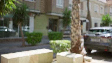 Bulanık sokak sahnesi, odak arabaları ve binaları olmayan, güneşli bir günde Bokeh efektleri ile odaksız bir açık hava perspektifi gösteren