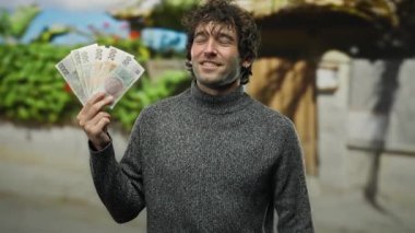 Bir şehir caddesinde elinde Czech Koruna banknotları tutan adam, el pençe divan gülümseyen, neşe ve başarı somutlaştıran canlı bir şehir ortamında.