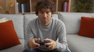 Oturma odasında video oyunu oynayan genç adam boş zamanların keyfini çıkarıyor. Mutluluk ve rahatlama..