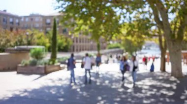 Marsilya 'da açık havada, bulanık insanlar ağaçlar ve Avrupa binalarıyla güneşli bir caddede yürür, dağılmış kentsel yaşamı yakalar.