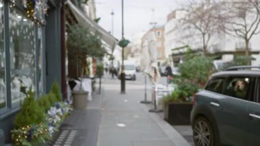 Kış boyunca Londra 'da Bokeh etkisi ile cadde, bulanık arka plan, dekore edilmiş mağaza penceresi, ve kaldırımda yeşil kaplamalı bir araba.