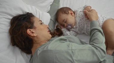 Kadın ve bebek, sıcak bir ev ortamında aile sevgisini ve bağlarını göstererek huzur içinde yatıyorlar..