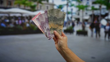 Endonezya 'nın endonezya paralarını elinde tutan bir adam, şehir merkezinde insanların bulanık geçmişine sahip, iş ya da finansal işlemleri öneren,.