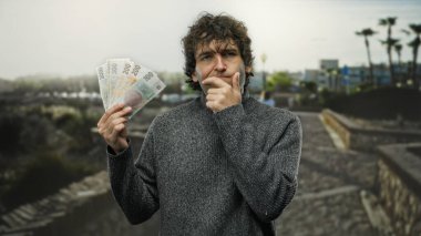 Bir şehir caddesinde Czech Koruna banknotları tutan bir adam, şehir dışında düşünce ve ekonomik karar verme mekanizması sergiliyor..