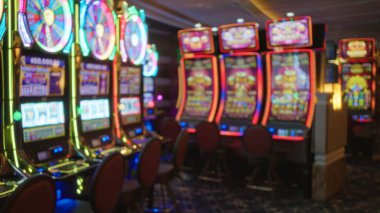 Vibrant neon slot machines blurred inside a bustling las vegas casino, highlighting the lively and colorful atmosphere typical of indoor gaming environments.