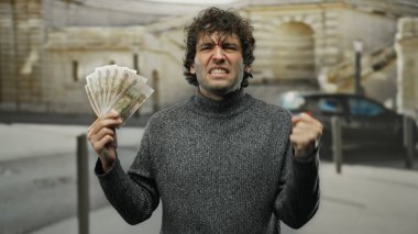 Hispanik bir adam, şehirde elinde Rus rublesi tutarken hayal kırıklığını gösteriyor. Şehir sokaklarında yaşanan mali stresi yansıtıyor..