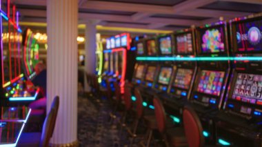 Canlı Las Vegas ortamında parlak kumar makineleriyle dolu renkli kumarhanedeki bulanık adam, canlı atmosferi ve kumarın heyecanını gözler önüne seriyor..