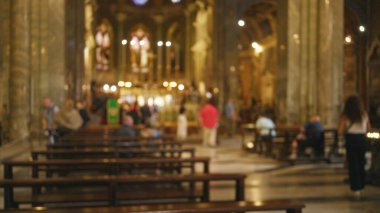 Süslü bir kilisenin içindeki bulanık figürler, dinsel bir atmosfer sergiliyor, zengin bokeh ve odağını kaybetmiş elementler manevi ortamı vurguluyor..