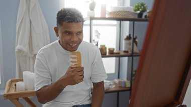 Genç adam sağlık ürünleriyle çevrili bir spa odasında şarkı söylüyor. Güzellik merkezinde neşeli ve neşeli bir atmosfer yaratıyor..