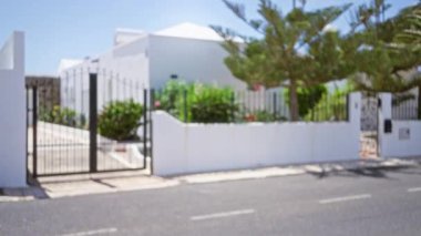 Lanzarote, kanarya adaları ve İspanya 'da parlak güneş ışığı altında siyah kapılı ve yemyeşil yemyeşil bir Beyaz Saray girişinin odaksız görüntüsü..
