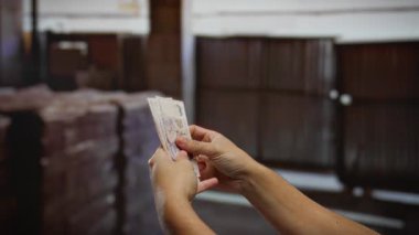 Kentsel inşaat sahasında kapalı alanlarda tek başına dolar sayan adam, sanayi ortamında sergilenen iş, yatırım ve finansal planlama.