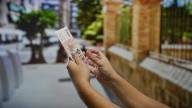 Kentsel bir sokak sahnesinde İzlanda Krona banknotlarını tutan eller para alışverişini ve mali yatırım kavramlarını resmediyor.