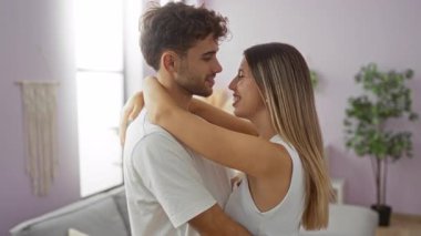 Sıcak bir oturma odasında kucaklaşan bir çift, aşık bir adama gülümseyen bir kadın, kapalı bir yerde..