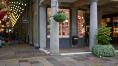 Bulanık Noel ışıkları ve dekorasyonları Covent Garden, Londra 'da hareketli bir caddeyi süslüyor..