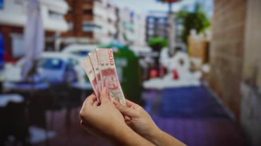 İsveç kronu banknotları elinde tutan adam sokak terasında iş yatırımları ve açık hava ortamında finans kavramları sergiliyor.