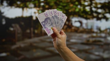 Bir şehir sokak ortamında, İsviçre Krona 'nın el ele tutuştuğu banknotlar, bir adamla birlikte bir iş ve yatırım temasını yansıtıyor..