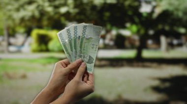 Güney Kore 'yi elinde tutan adam açık havada bulanık park geçmişi olan, doğaya karşı para gösteren zenginliği ve finansal refahı simgeleyen banknotlar kazandı..