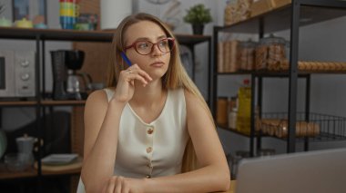 Çalışma odasındaki kalemle düşünen kadın raflar ve modern dekorlarla çevrili, profesyonel bir ortamda derin düşüncelere dalmış bir ruh hali içinde..