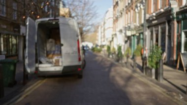 Kış boyunca sessiz bir Londra caddesinde bulanık bir minibüsün olduğu sokak manzarası. Bokeh ışıkları ve sönmüş binalar sergileniyor..