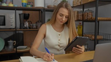 Ofis ortamında çalışan, deftere yazı yazan, tablet kullanan, ofis malzemeleriyle çevrili ve raflarda kahve yapan bir kadın..