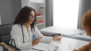 Doktor, bir klinikte hastayla tartışıyor, sağlık hizmetleri, kadın doktor, hasta bakımı, tıbbi danışma ve kapalı bir hastane ortamında yetişkin kadınların altını çiziyor..