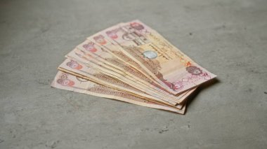 Birleşik Arap Emirlikleri kara para ve finansal konsepti temsil eden somut bir yüzey üzerinde sergilenen dirham banknotları.