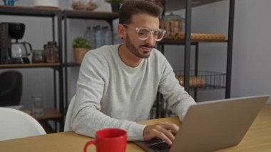 Ofis ortamında kırmızı bardakta boğazı ağrıyan genç bir adam ofis malzemeleri ve dizüstü bilgisayarla çevrili iş ve hastalık kombinasyonları sergiliyor..