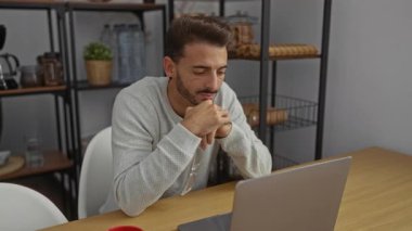 Rahat ofis ortamında dizüstü bilgisayara gülümseyen genç bir adam arka planda raflarla verimli ve rahat bir çalışma ortamı öneriyor..