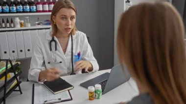 Modern klinikteki kadın hastalara danışmanlık yapan ve raflarda tıbbi malzemeler bulunan bir doktor, profesyonel sağlık hizmetlerinin kapalı alanlarda uygulandığını gösteriyor..