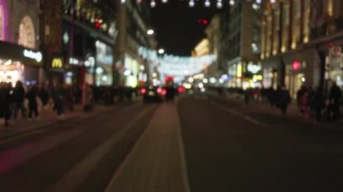 Londra 'daki bulanık gece sahnesi, hareketli bir sonbahar akşamında bokeh ışıkları ve insan siluetleriyle dağılmış sokakları gösteriyor..