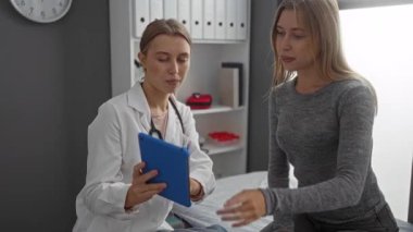 Doktor, iki kadınla birlikte klinikteki hastaya evde sağlık hizmetlerini tartışan tableti gösteriyor..