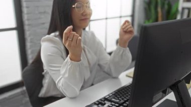 Asyalı bir kadın modern ofiste masa başında bilgisayarla meditasyon yapıyor, sakin, sakin, iş sırasında evde huzurlu bir atmosfer sergiliyor..