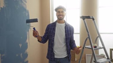 Parlak apartman içinde merdiven başında tekerlekli merdiveni olan genç bir adam..