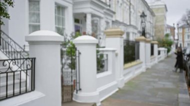 Açık hava sokak sahnesinde Chelsea, Londra 'da kaldırımda klasik mimari ile bulanık bir kadın görülüyor. Birleşik Krallık' ta kış havası ve şehir cazibesi sergileniyor..