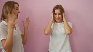 Pembe bir duvarın önünde durmuş tartışan kadınlar aile ortamında kız kardeşler arasındaki duygu ve bağlantıyı paylaşıyorlar..