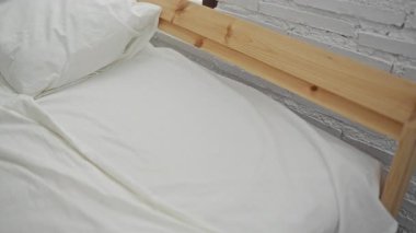 Rahat bir yatak odasında, rahat bir yatakta dinlenen bir kadın ev ortamında sükunet ve rahatlık sergiliyor. Huzurlu bir sabah anını vurguluyor..
