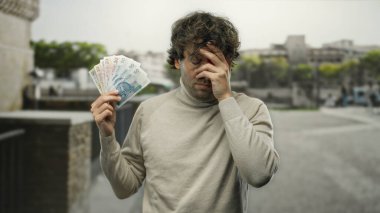 Bir şehir caddesinde elinde Polonya zloti banknotları tutan Hispanik bir adam vurgulanmış görünüyor, bu da Avrupa kentsel ortamında mali kaygılar olduğunu gösteriyor.