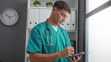 Klinikteki genç adam panoya önlük yazıp raflar ve saatle modern hastane odasında dururken....