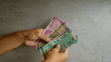 Hindistan 'da somut bir arkaplan karşısında Hindistan Rupisi sayan eller para transferini gösteriyor