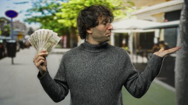 Bir elinde Rus rublesi olan İspanyol bir adam, bir elinde para değişimi ya da finansal karar alma önerisi sunuyor..