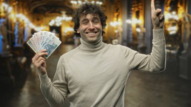 Müzedeki İspanyol asıllı adam gülümseyip işaret ederken aynı zamanda zloti banknotlarını tutuyor, kültürel ve finansal unsurlarla iç içe ve dinamik bir sahne yaratıyor..