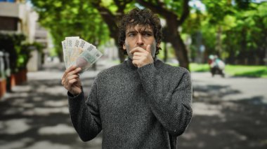 Elinde Czech Koruna banknotları tutan adam şehir dışındaki bir sokakta durup şehir hayatının özünü yakalıyor..