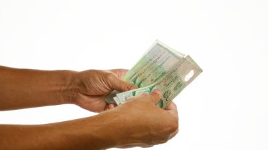 Finansla ilgili bir konsept için beyaz izole bir arkaplan üzerinde tekli dolar tutan eller