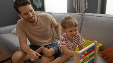 Baba ve oğul renkli bir abaküs ile birlikte oturma odasındaki kanepede oynuyorlar. Evdeki aile sevgisini ve çocukluk anılarını tasvir ediyorlar.