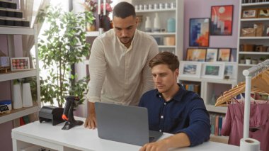 Ev dekorasyonu mağazasında çalışan adamlar dizüstü bilgisayar kullanıyor ve ev ortamında çeşitli dekoratif malzemelerle çevrili..