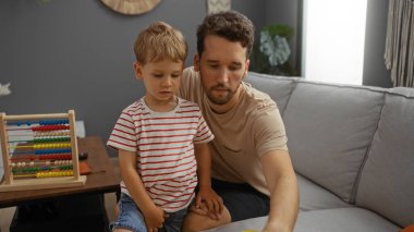 Baba ve oğul, masada renkli bir abaküs ile sıcak bir oturma odasında birlikte vakit geçiriyorlar.